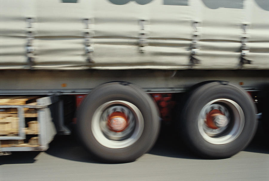 Truck driving on road, section (blurred motion) Photograph by Sami Sarkis