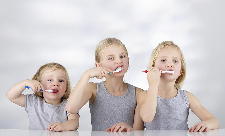 Tthree children brushing their teeth Photograph by Simon Katzer