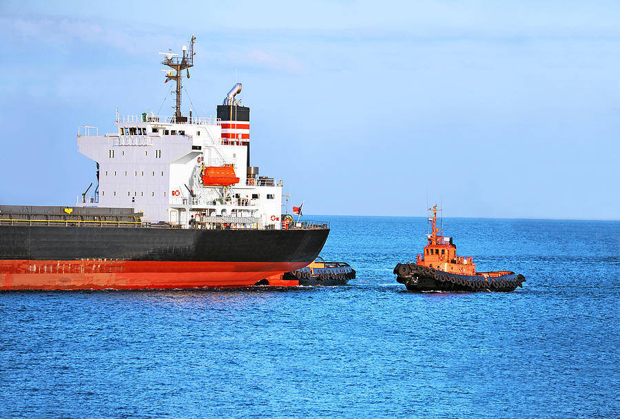 Tugboat assisting cargo ship Photograph by Unkas_photo