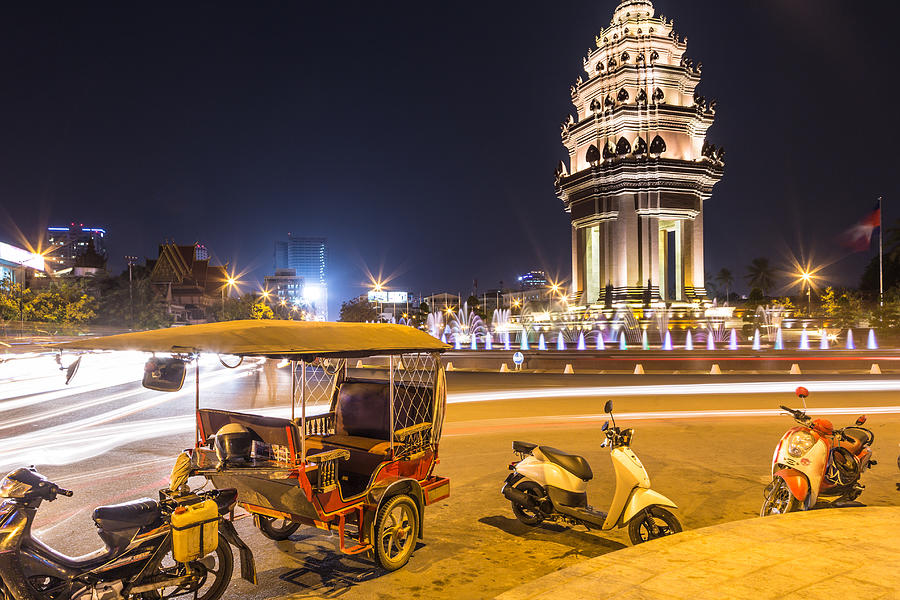 Tuk Tuk parked in front of the Independance monument, in Phnom Penh, Cambodia Photograph by @ Didier Marti