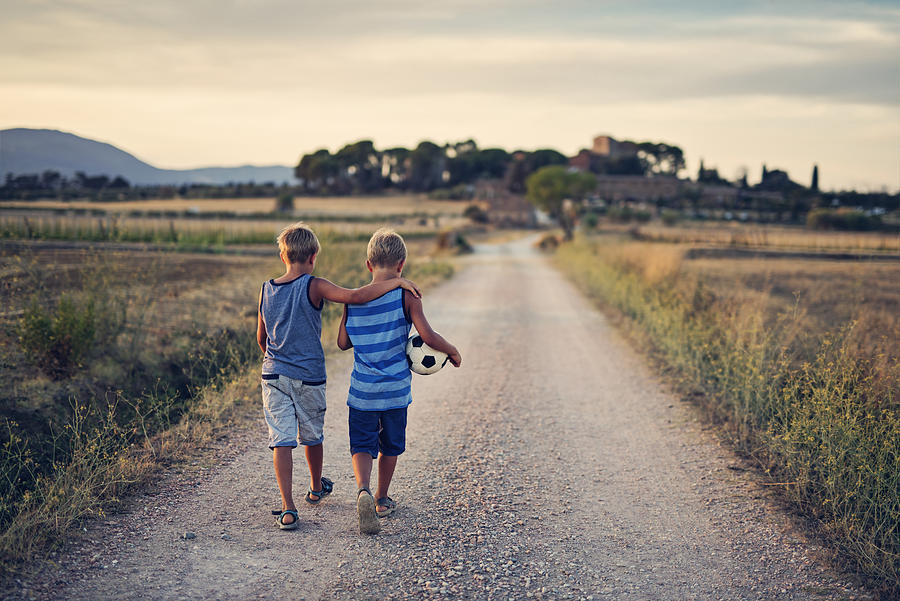 Twin brothers returning home after playing soccer. Photograph by Imgorthand