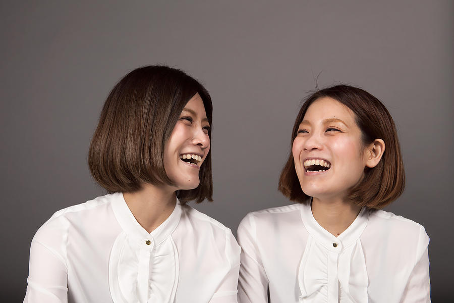 Twin sisters laughing loud Photograph by Taiyou Nomachi