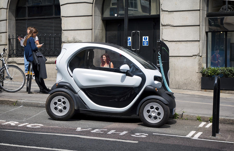 Twizy electric city car recharging in a London street Photograph by Whitemay