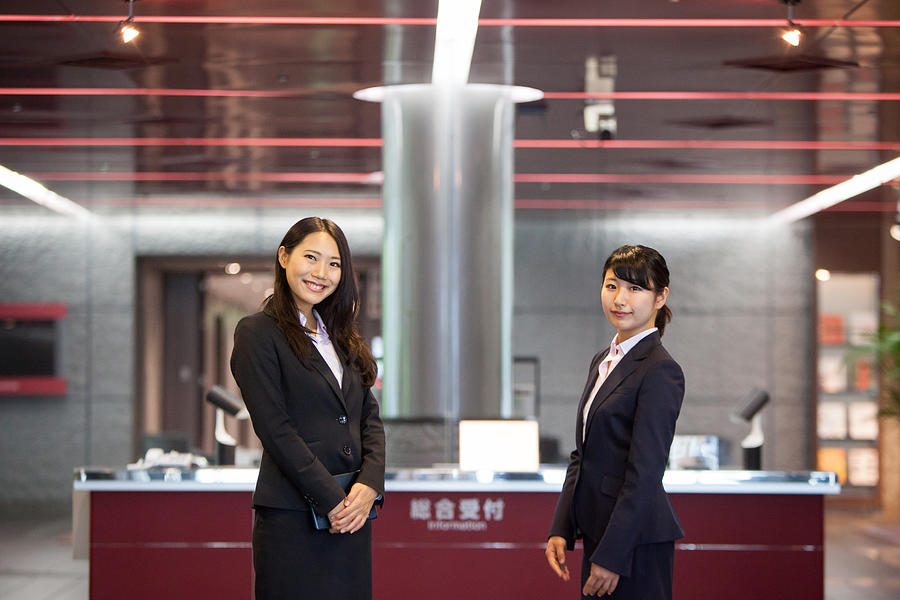 Two Beautiful Japanese women await at reception desk Photograph by Nattrass