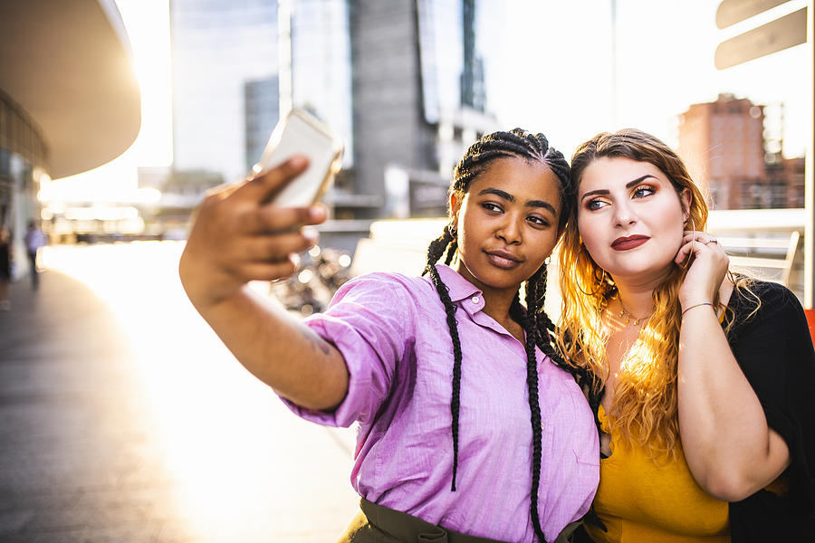 Two beautiful women making a selfie. Photograph by MStudioImages