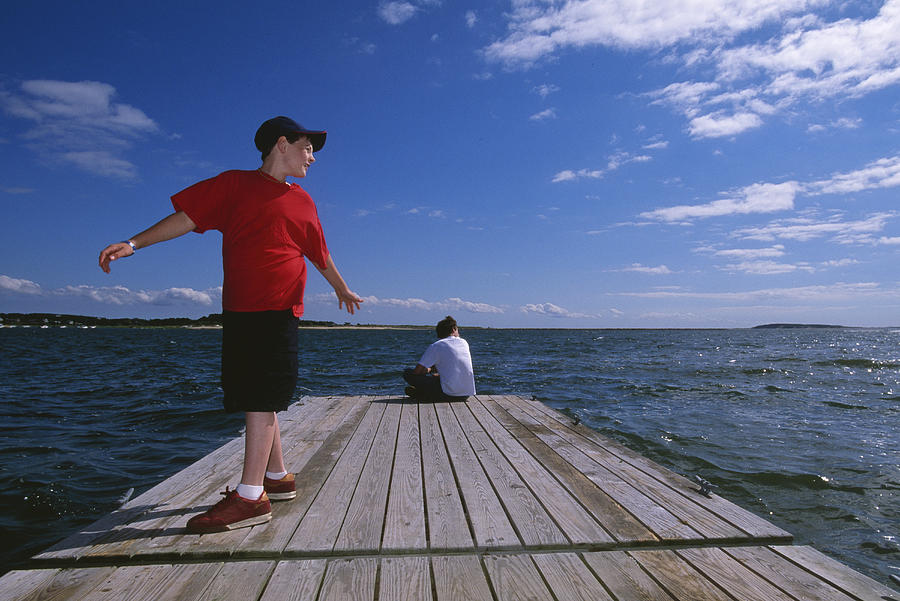 Two boys (10-16) on pier Photograph by Grant Faint