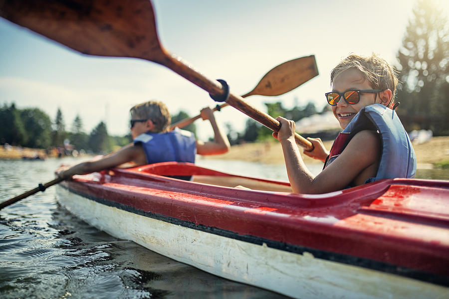 Two boys enjoying kayaking on lake Photograph by Imgorthand