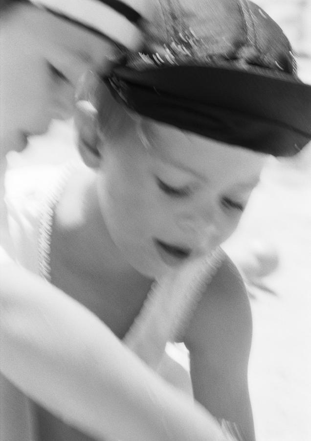 Two boys with hats looking down, close-up, b&w Photograph by Laurence Mouton