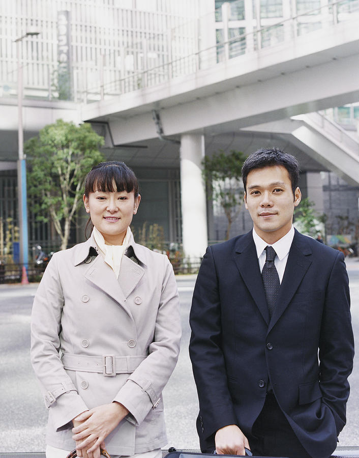 Two Business Executives Standing Side by Side, with a Footbridge in the Background Photograph by A J James