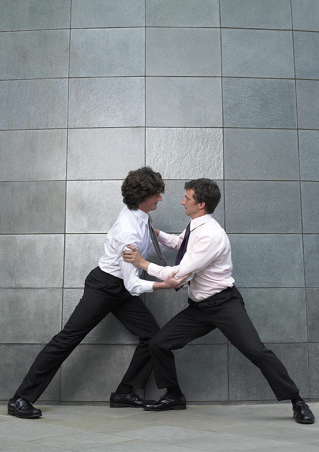 Two businessmen fighting, side view Photograph by Michael Blann