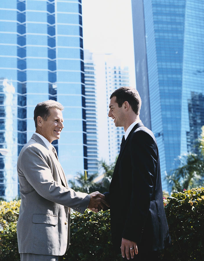 Two Businessmen Shaking Hands in the City Photograph by Digital Vision.