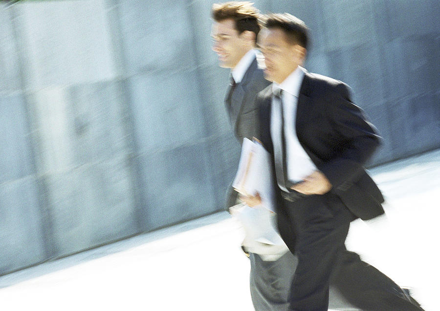 Two businessmen walking outdoors, blurred motion Photograph by Eric Audras