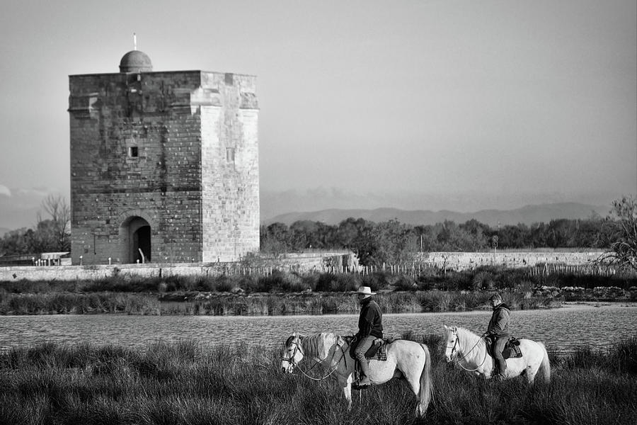 Two Camargue gardians by the Carbonnieres Tower Photograph by Jean Gill