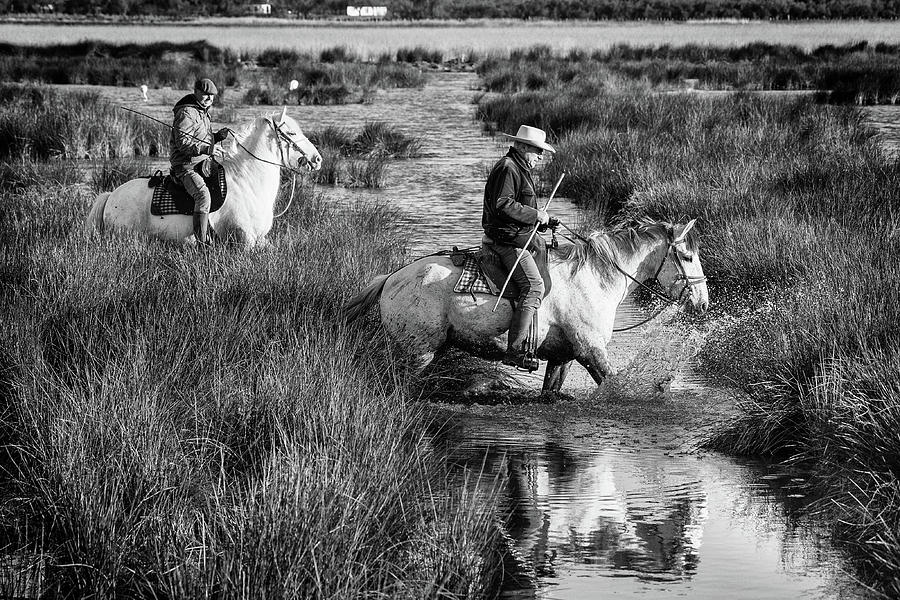 Two Camargue gardians crossing the stream Photograph by Jean Gill
