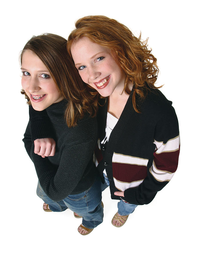 Two Caucasian Teenager Girls In Jeans And A Black Sweaters Smiles Up Into The Camera Photograph by Photodisc