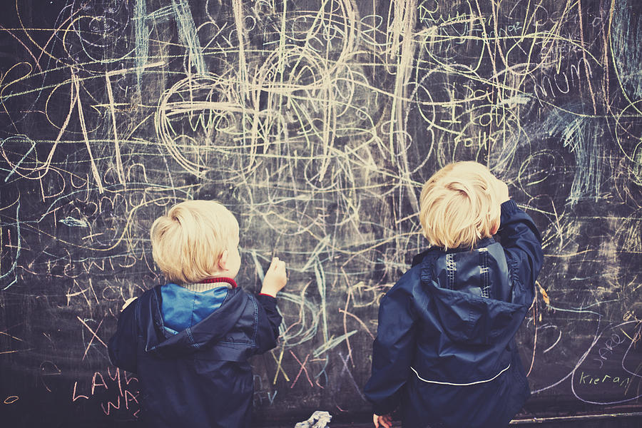 Two children drawing on board Photograph by Sally Anscombe