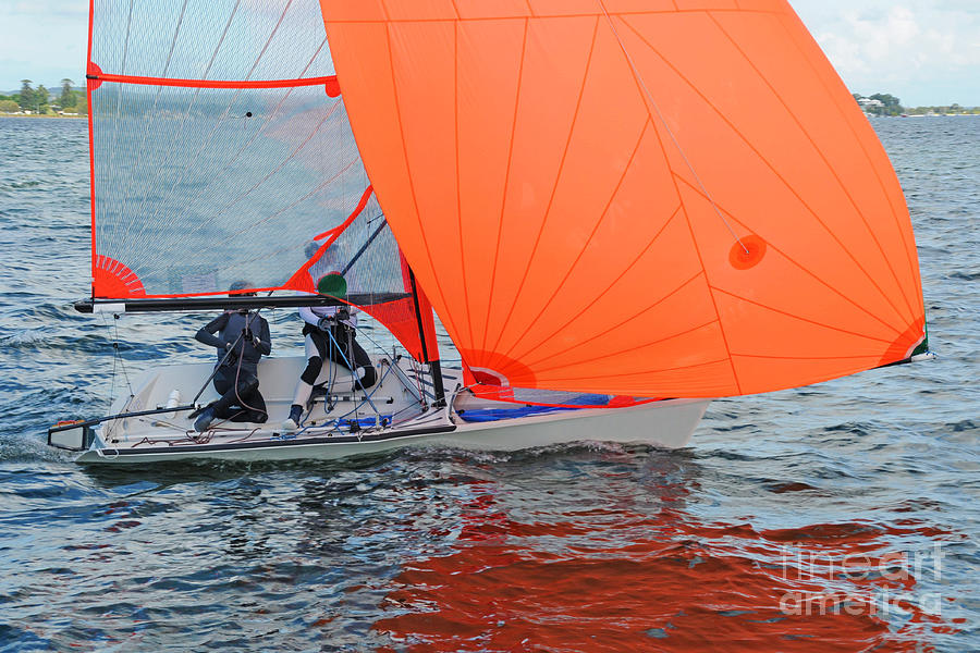 Two children sailing a racing dinghy with a large fully deployed Photograph by Geoff Childs