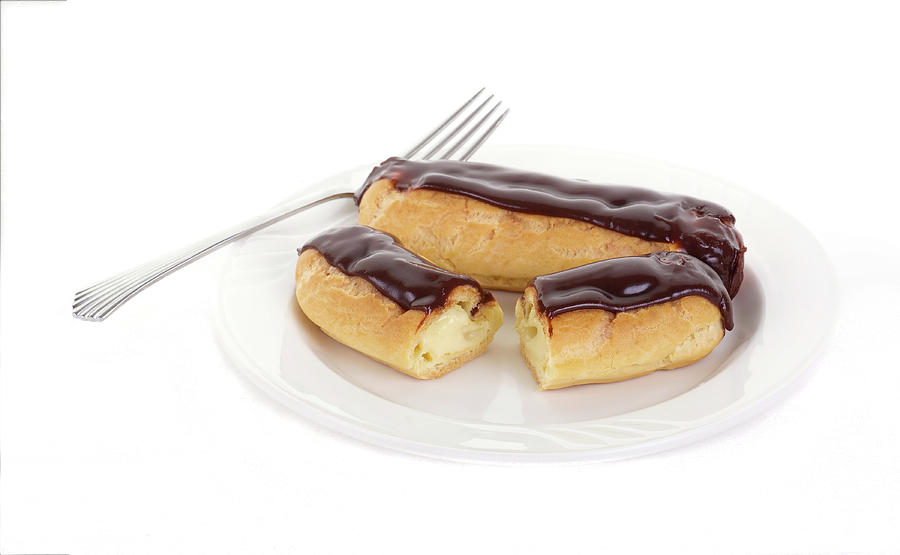 Two Chocolate Eclairs on a White Plate with a Fork Photograph by Darryl Brooks