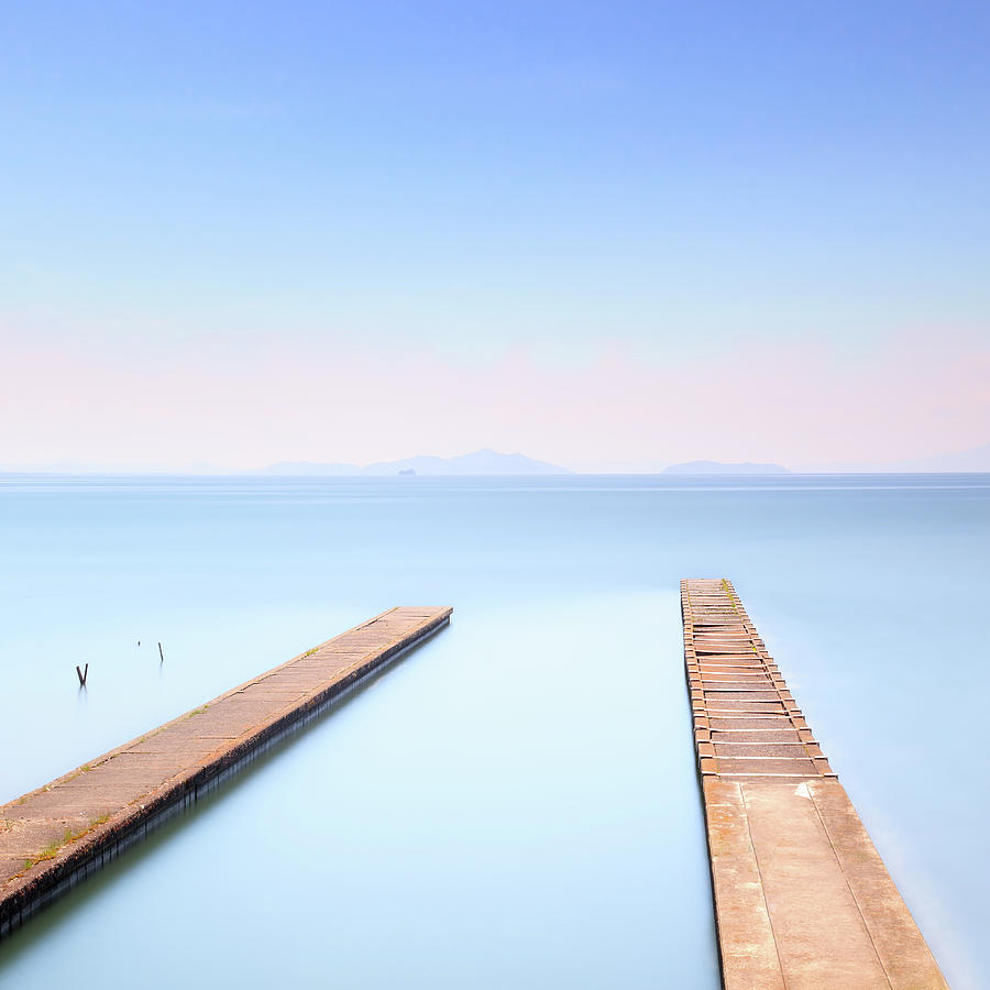 Two concrete pier or jetty on a blue sea. Photograph by Stefano Orazzini