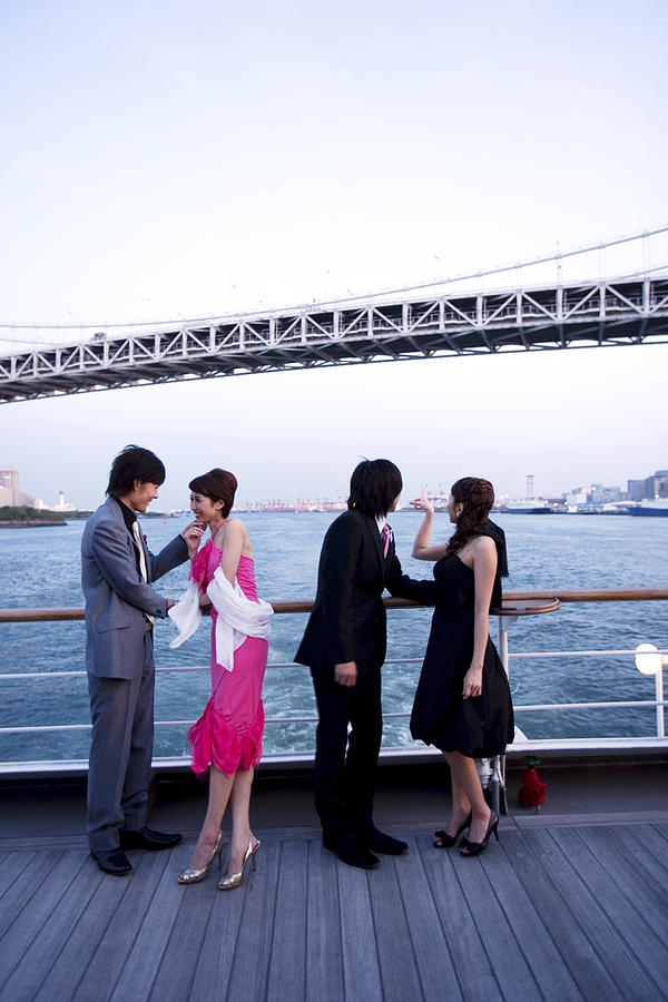Two couples enjoying the view on cruise ship, low angle view Photograph by Luxe Party