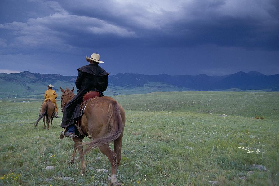 Two Cowboys Riding The Range In Montana Photograph by John P Kelly