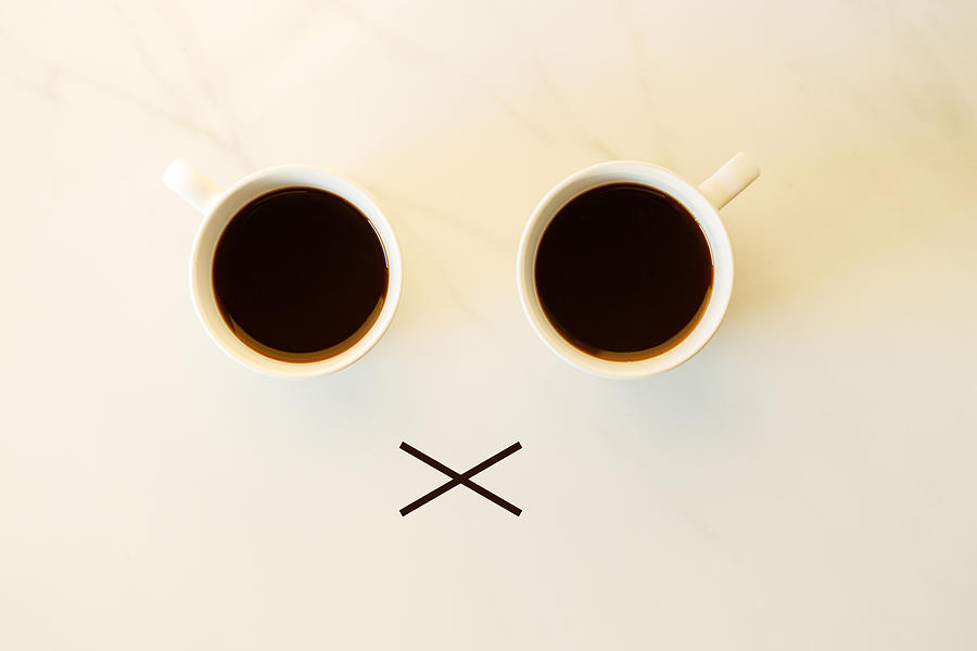 Two cups of coffees arranged as human face with line showing emotion. dissatisfied Photograph by Janecocoa