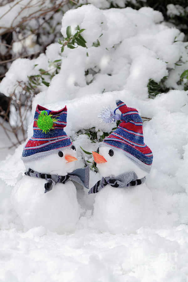 Two cute little snowmen dressed for snow Photograph by Simon Bratt