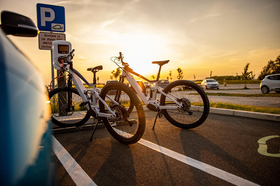 Two electric bicycles being charged at the electric vehicle charging station Photograph by SimonSkafar