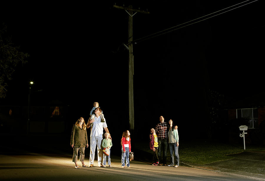 Two families standing looking up at night sky Photograph by Nick Bowers