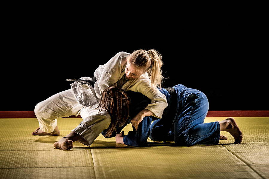 Two female judokas wrestling on a tatami mat Photograph by Vm