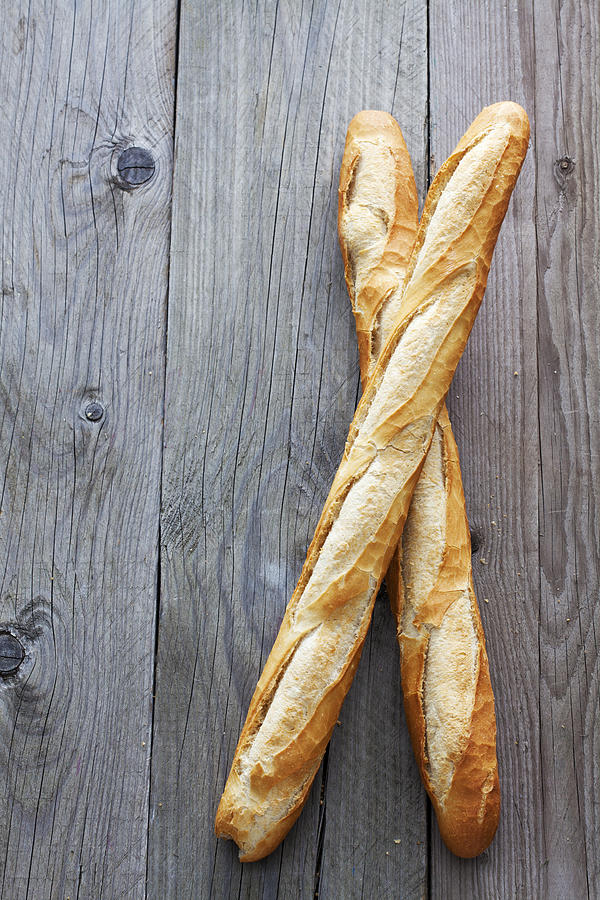 Two French baguettes on grey wood Photograph by Westend61