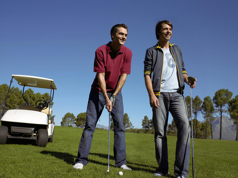 Two Friends Standing Together on a Golf Course Photograph by Digital Vision.
