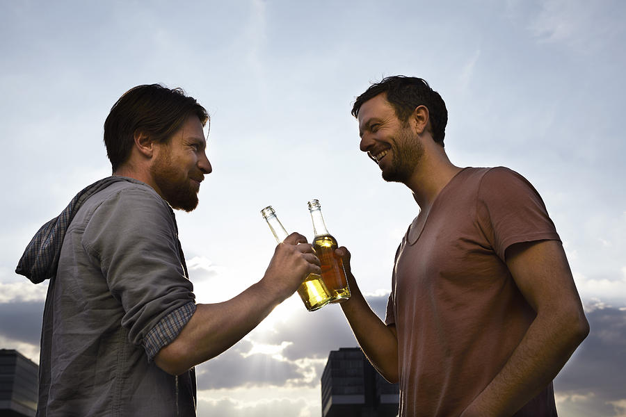 Two friends with beer bottles outdoors Photograph by Westend61