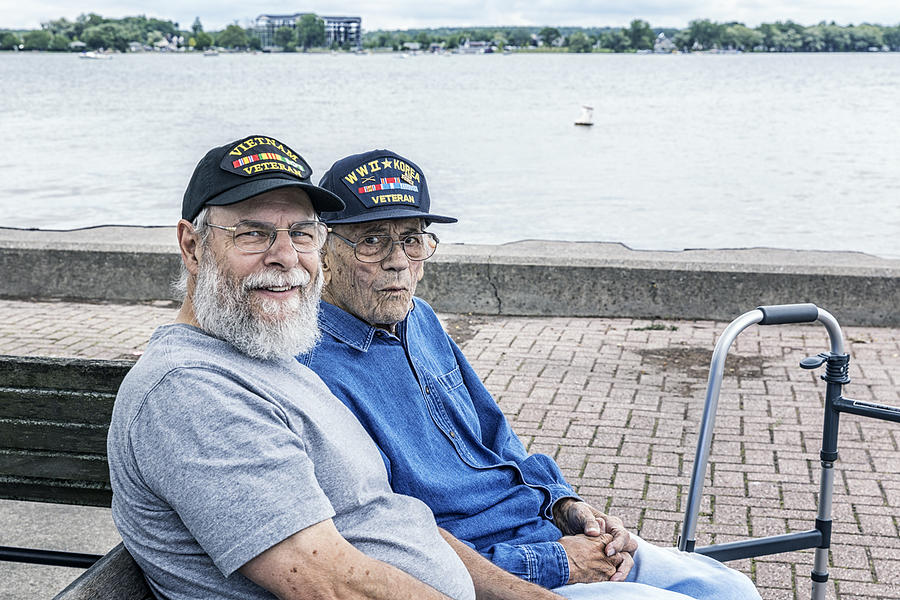 Two Generations of Senior Adult USA Military Veterans Sitting at the Lake Photograph by Willowpix