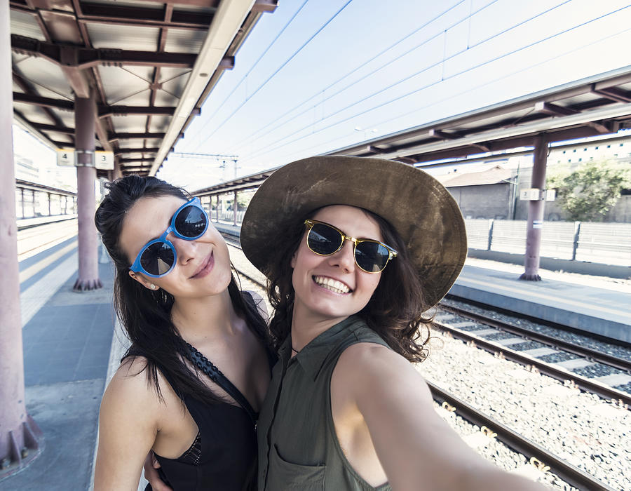 Two girlfriends in a train station Photograph by Elitsa Deykova