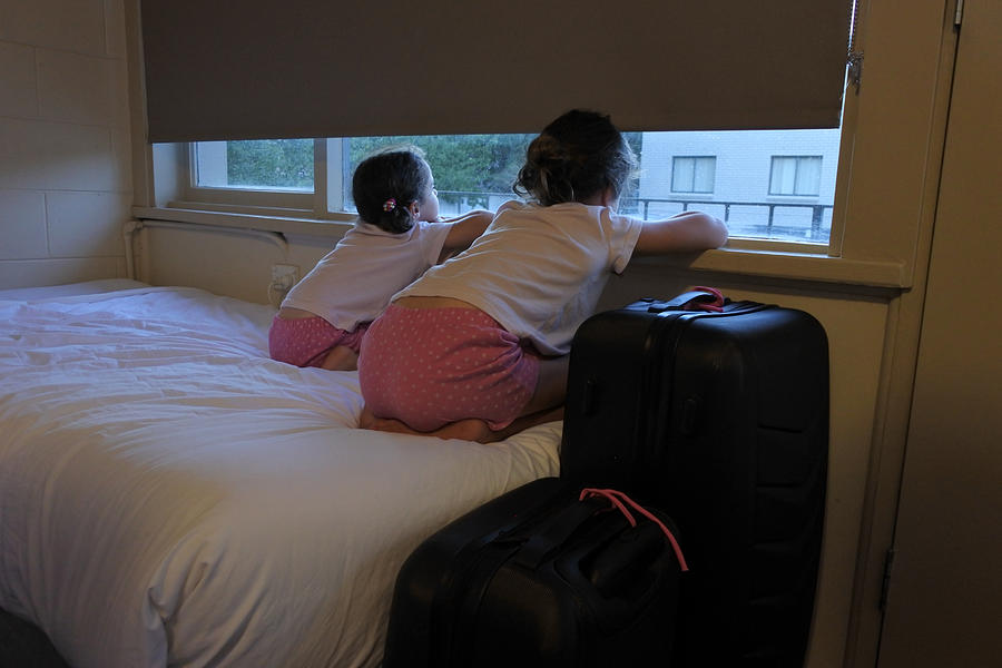 Two girls looking out from a motel window Photograph by Rafael Ben-Ari