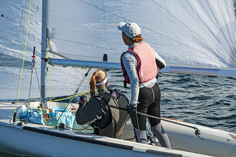 Two Girls One Standing Other Sitting Sailing A Racing Skiff Clos Photograph