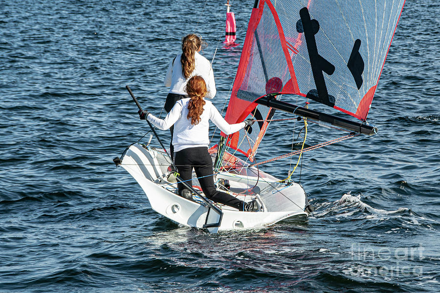 Two Girls Sailing small sailboat with long red hair viewed close Photograph by Geoff Childs