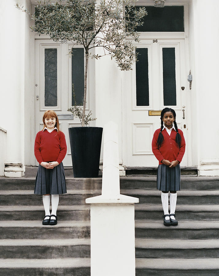 Two Girls Standing Outside the Front Doors of Their Townhouses Photograph by Lottie Davies