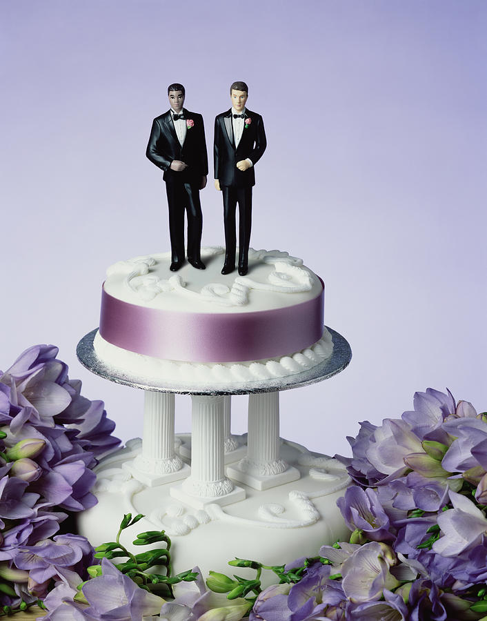 Two groom figurines on wedding cake, close-up Photograph by Peter Dazeley
