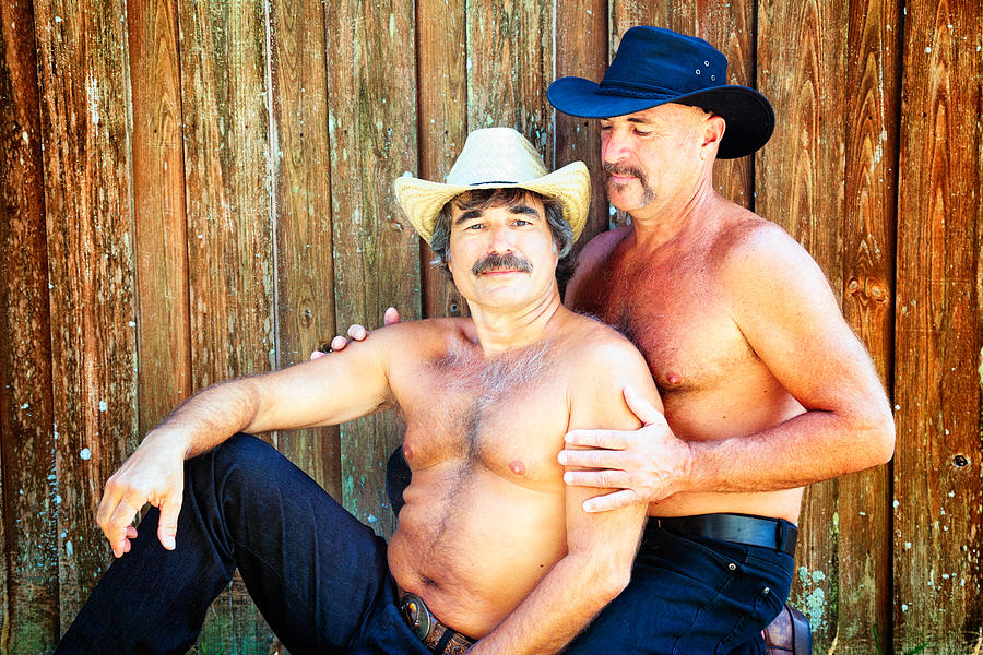 Two hairy bear affectionate cowboys against wooden fence Photograph by NicolasMcComber