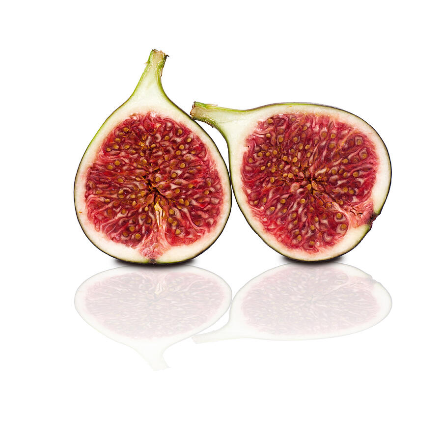 Two Halves Of Figs Isolated On White Background Photograph by Assalve