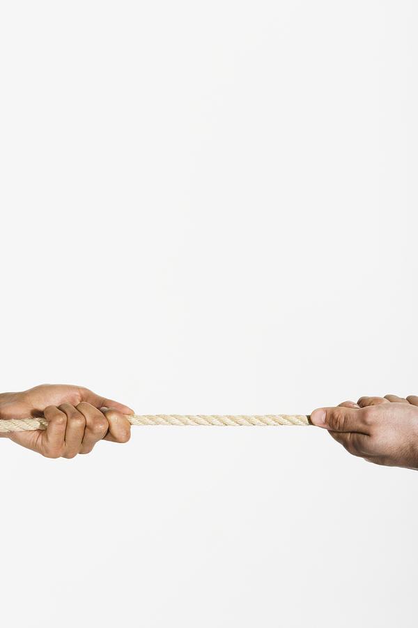 Two hands pulling opposite ends of a rope Photograph by Martin Barraud