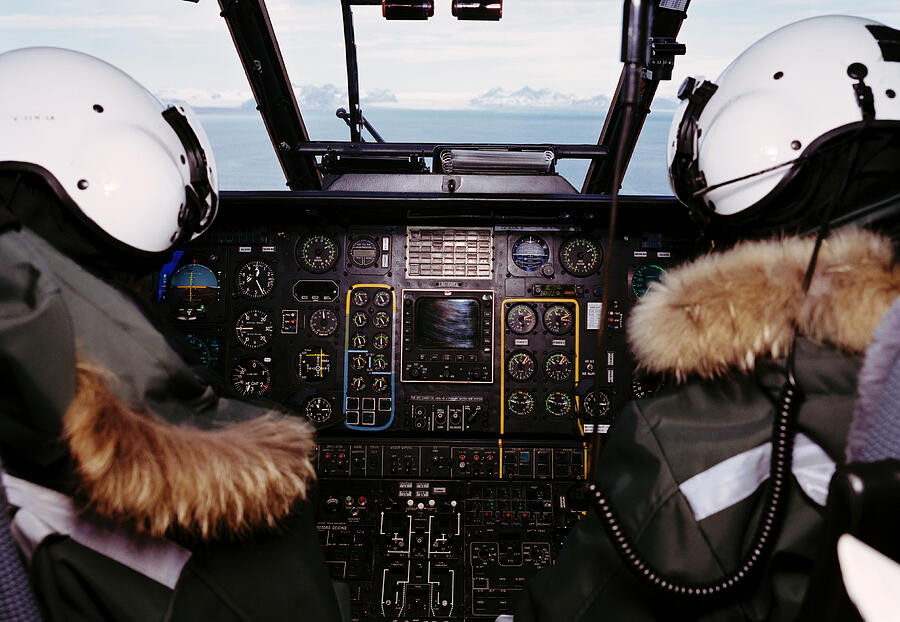 Two helicopter pilots in cockpit, rear view Photograph by Jorn Georg Tomter