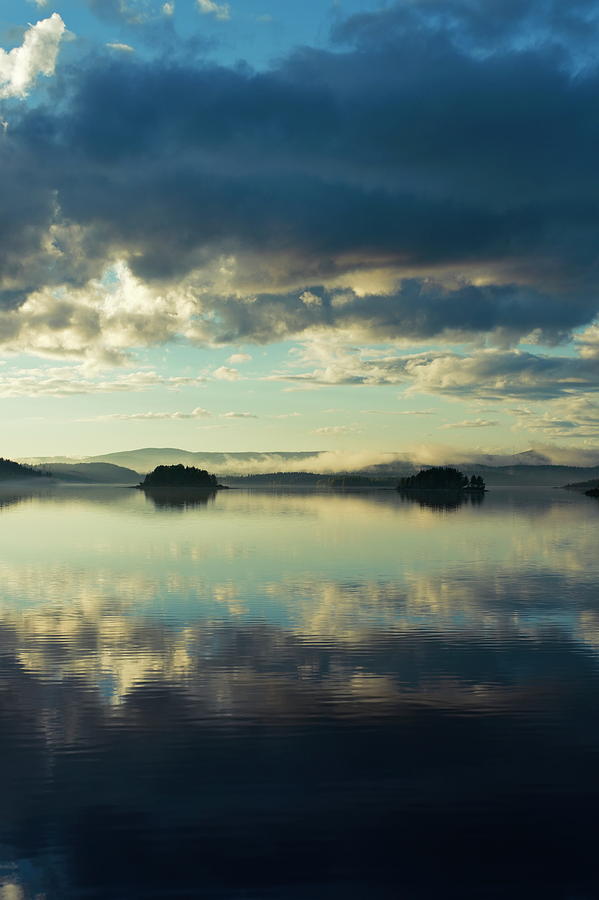 Two islands and the cloudy sky are reflected in a glassy lake Photograph by Ulrich Kunst And Bettina Scheidulin