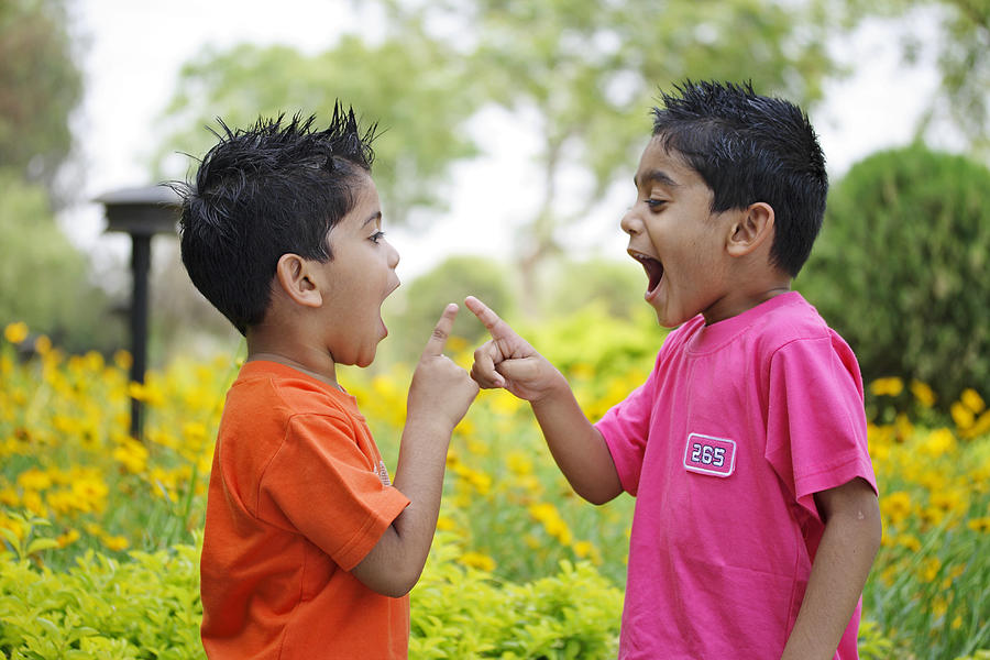 Two kids pointing fingers at each other Photograph by Visage