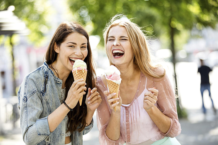 Two laughing young women with ice cream cones Photograph by Westend61