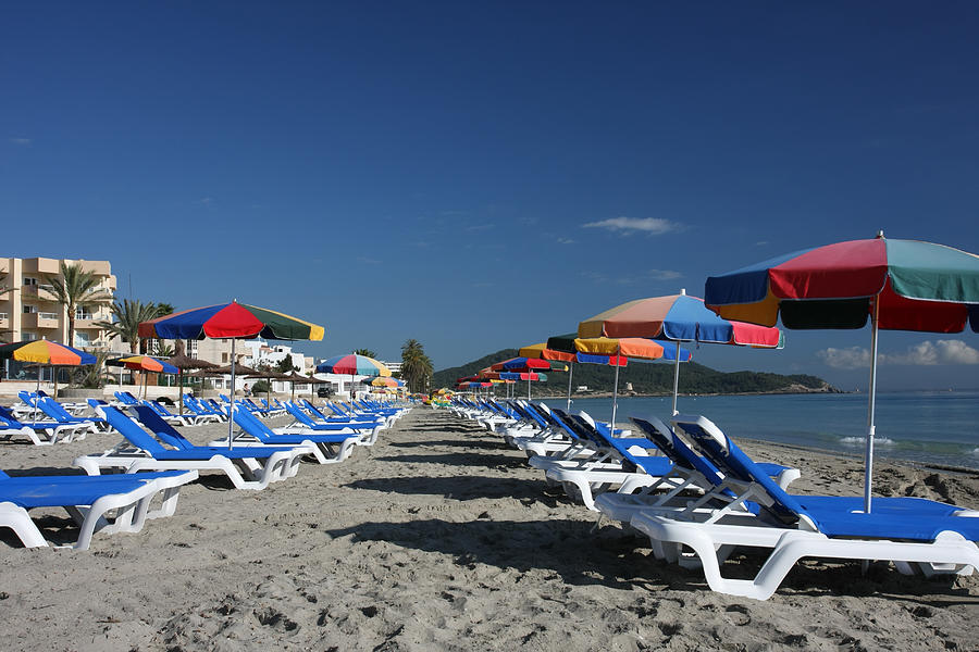 two lines of beach beds and sun umbrellas at Ibiza Photograph by Arturbo