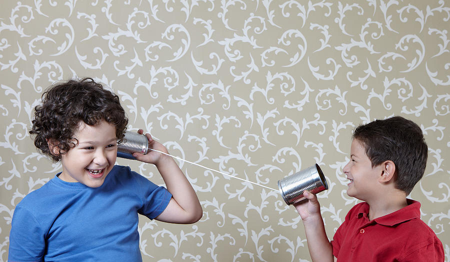 Two little boys playing with a tin can telephone Photograph by Xefstock