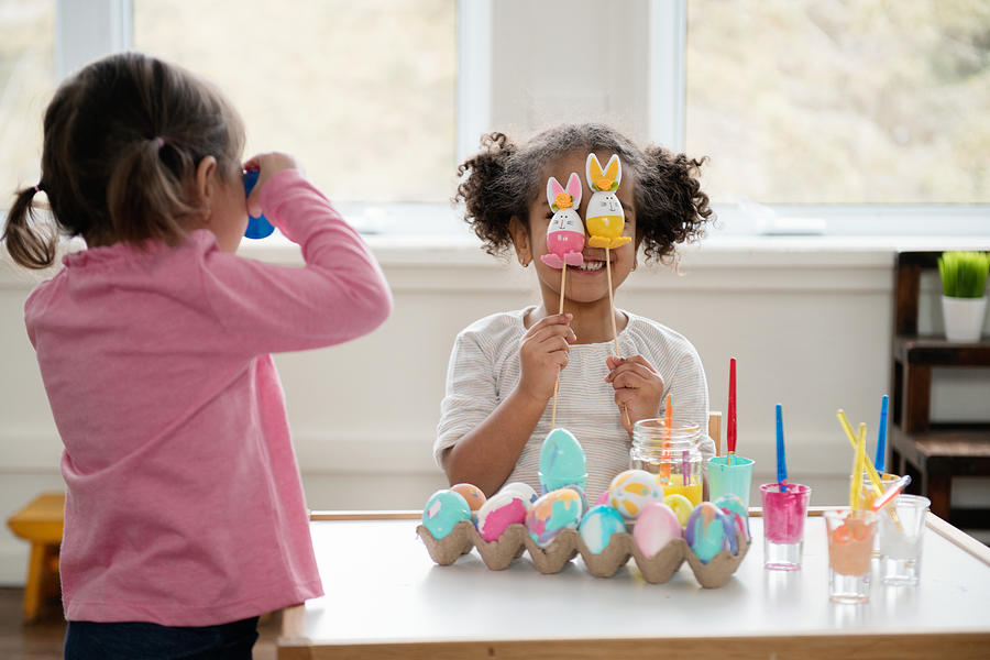 Two Little girls looking through Easter eggs. Photograph by Manonallard